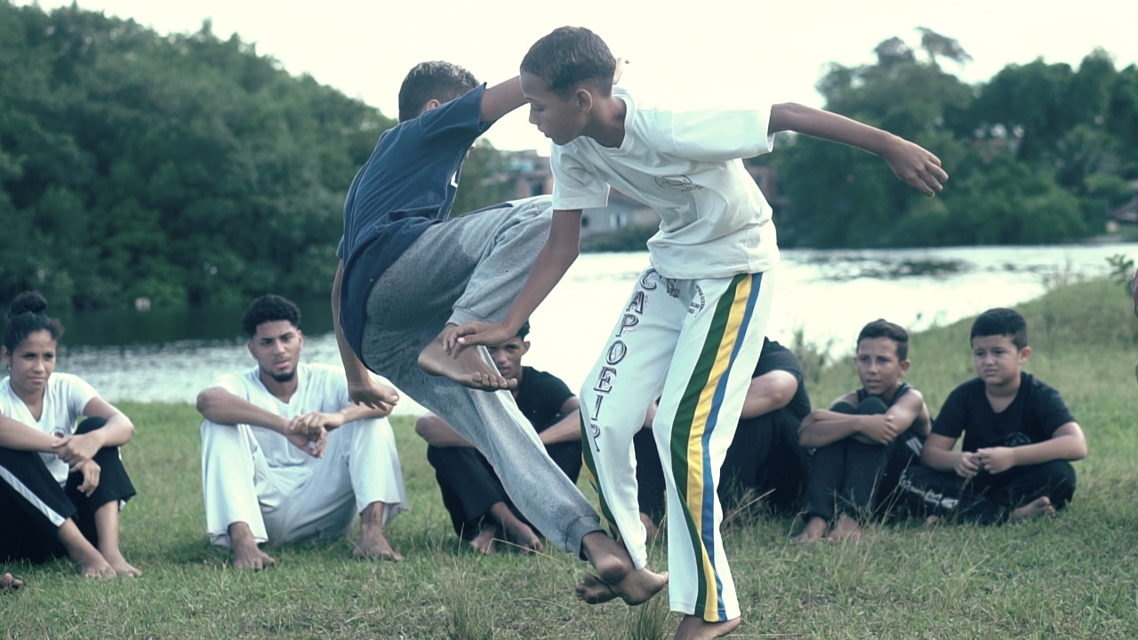 O documentário Meninos Guerreiros relata a trajetória do grupo de capoeira homônimo desde sua origem na extinta Vila Parisi em Cubatão, a chegada em São Vicente e expansão à Europa