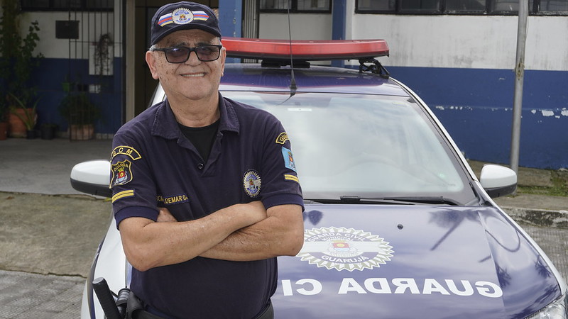 GCM Valdemar de Freitas Santos em frente a viatura da corporação