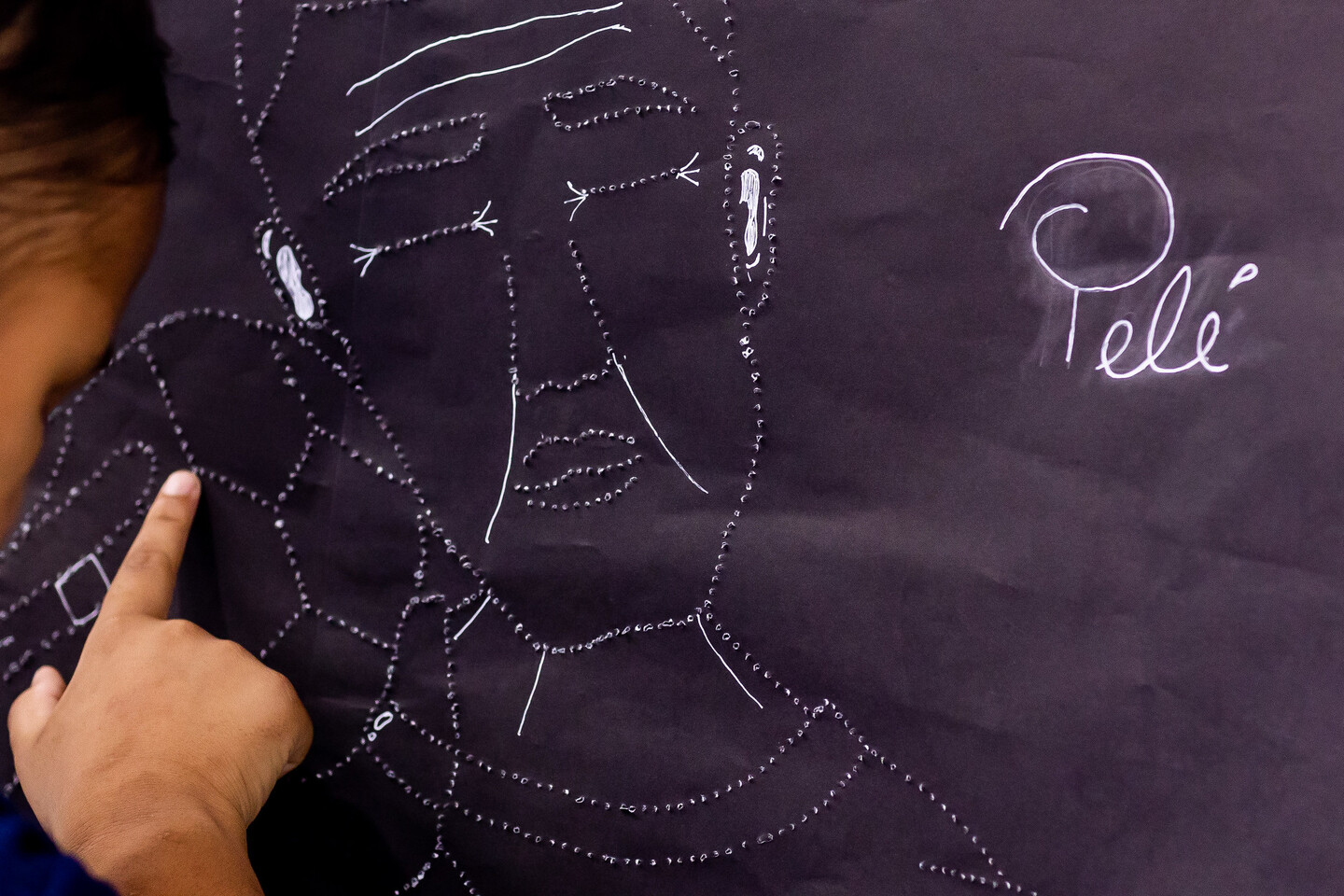 A professora Camila Jéssica de Sá, especialista em braile, traduziu a obra de um estudante por meio de punção (técnica de textura na página)