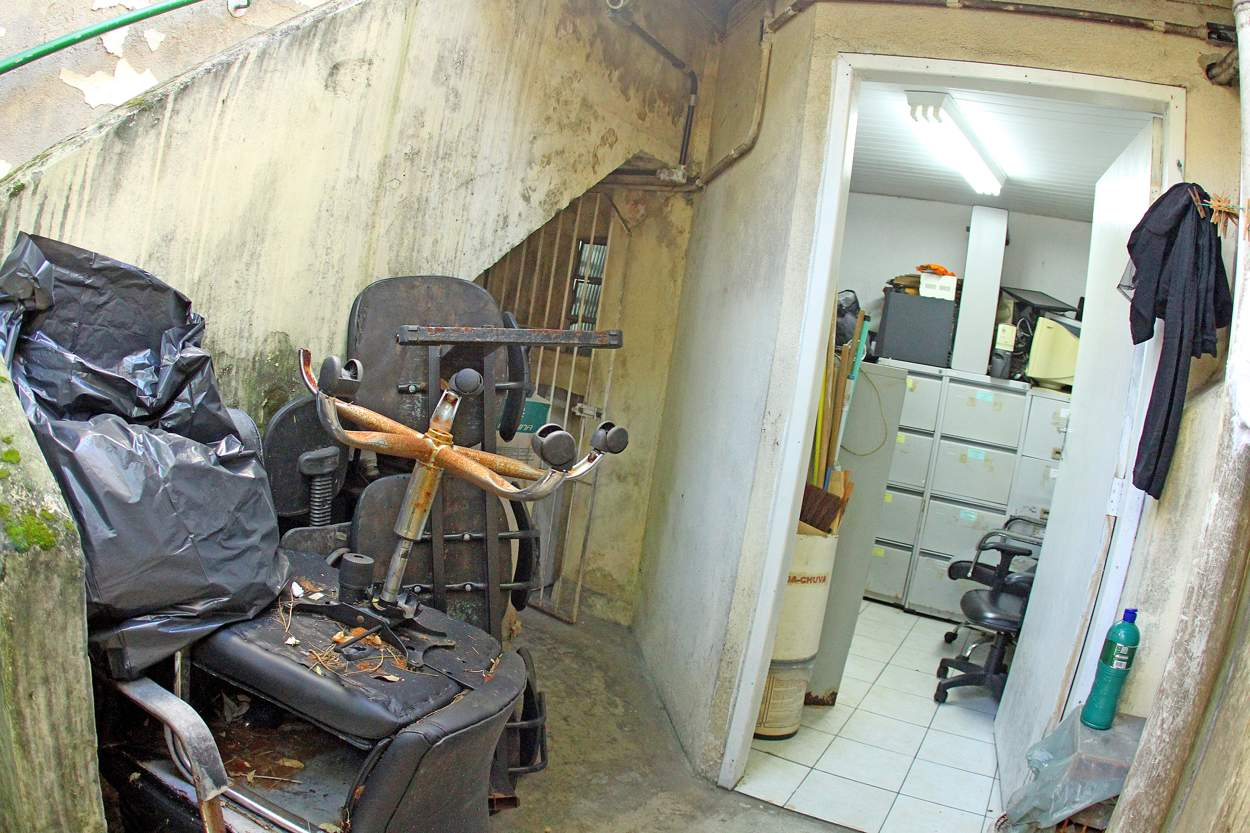 A profissional da limpeza tem que ficar num porão sob a escada, dividindo espaço abafado com vários materiais. Fora é ainda pior