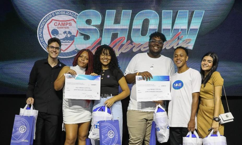 Thalita, de vestido branco, exibe certificado da conquista ao lados dos colegas do Camps