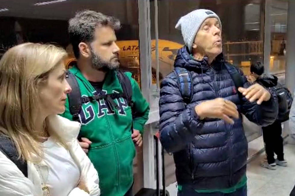 Roberto Mantovani (direita), esposa e genro são abordados pela PF ao desembarcar no Brasil