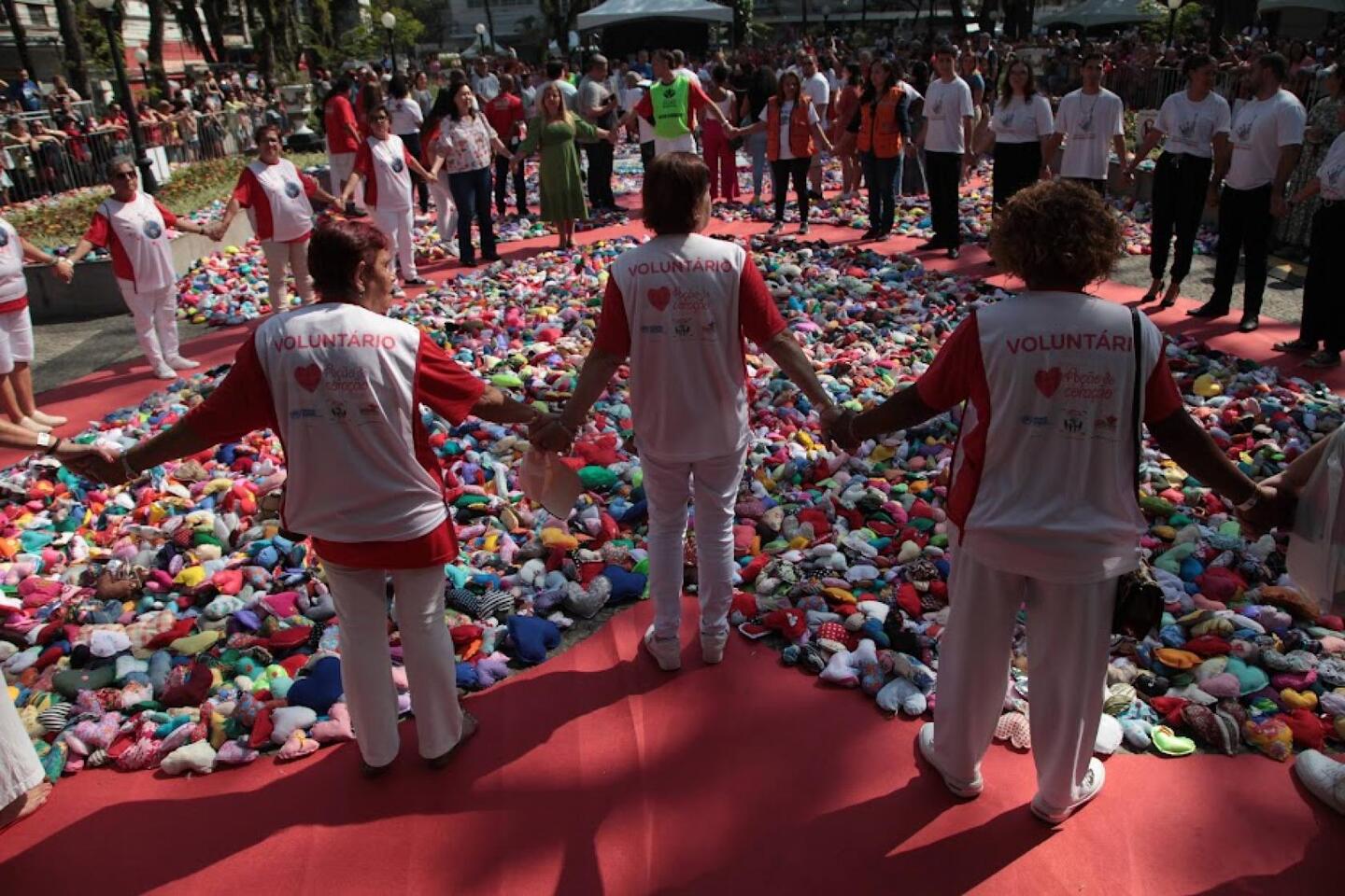Após um abraço coletivo comandado por Alexandre Camilo, os corações confeccionados ao longo de meses espalhados no chão da praça foram, enfim, distribuídos aos presentes