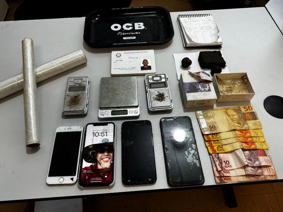 Além dos entorpecentes, foram recolhidos 4 celulares, 3 balanças de precisão, cadernos com anotações do tráfico de drogas, rolos plásticos e bandejas plásticas
