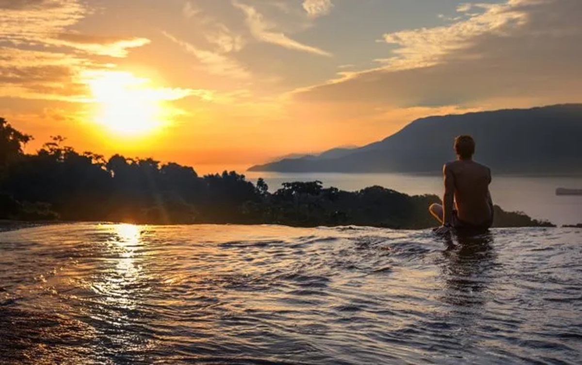 Cachoeira forma piscina natural de borda infinita e vista para o mar no Litoral de SP
