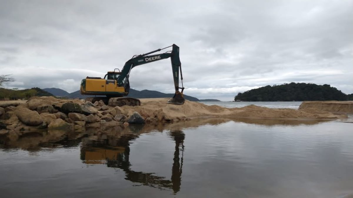 Uma escavadeira PC está sendo utilizada para retirar areia da foz e aprofundar a calha do rio