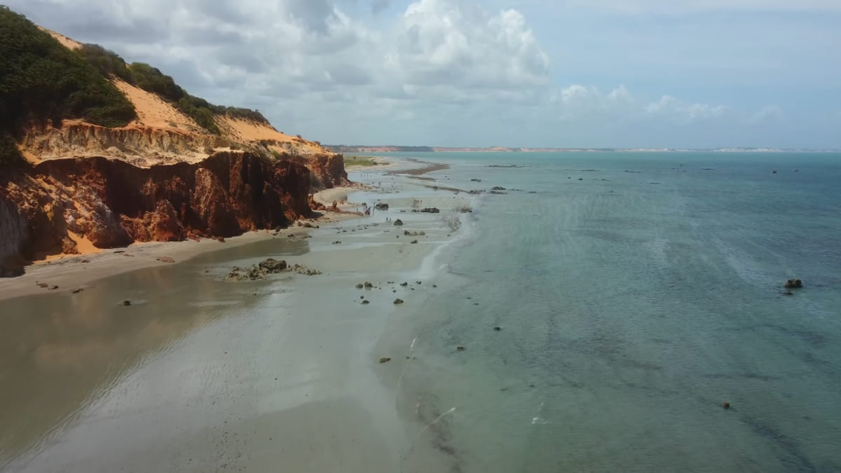 Praia mescla dunas e falésias em meio a natureza